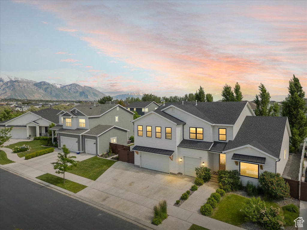 View of front of house featuring a garage, driveway, a standing seam roof, a residential view, and metal roof