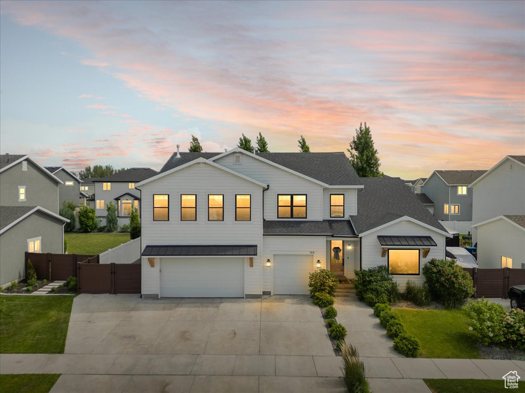 View of front of house featuring concrete driveway, a garage, a gate, and a residential view