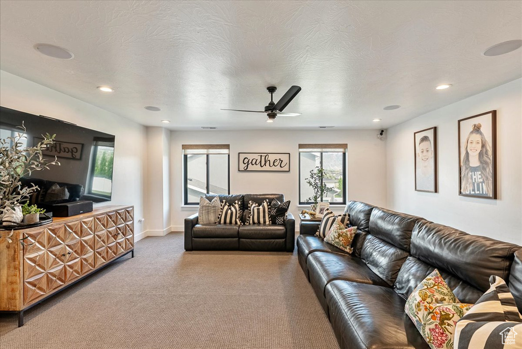 Carpeted living area with a ceiling fan, recessed lighting, and baseboards