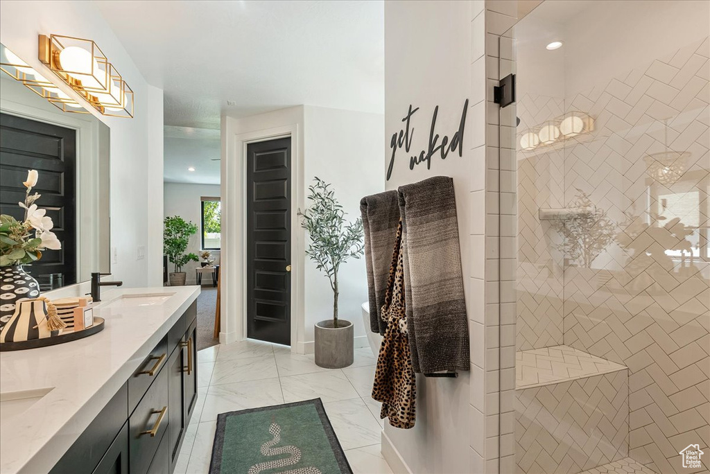 Bathroom featuring double vanity, a walk in shower, and recessed lighting