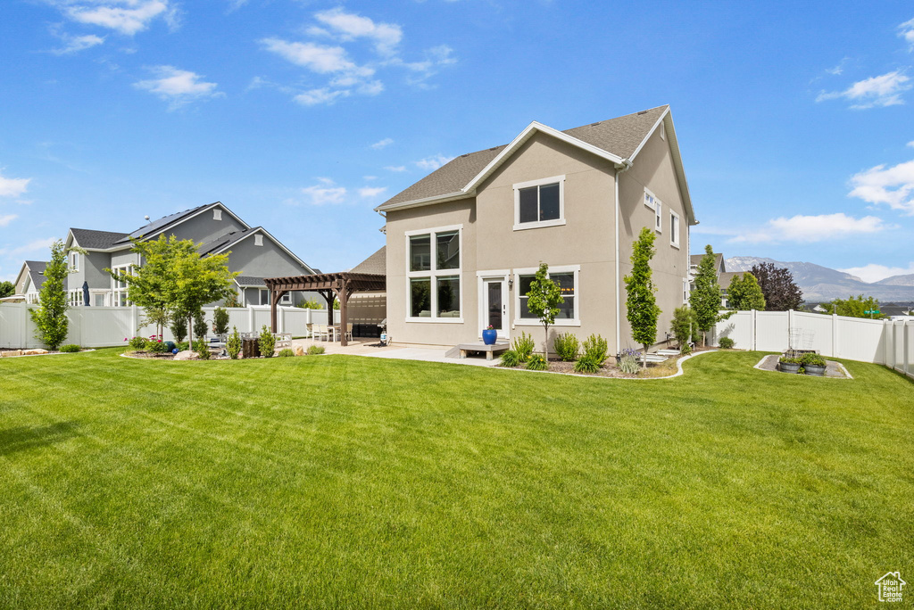 Back of house with a patio area, a pergola, a mountain view, and stucco siding