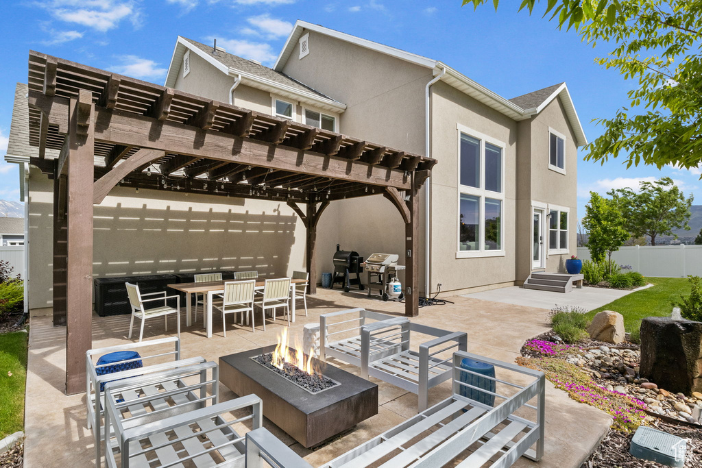 View of patio featuring a fire pit, outdoor dining space, area for grilling, and a pergola