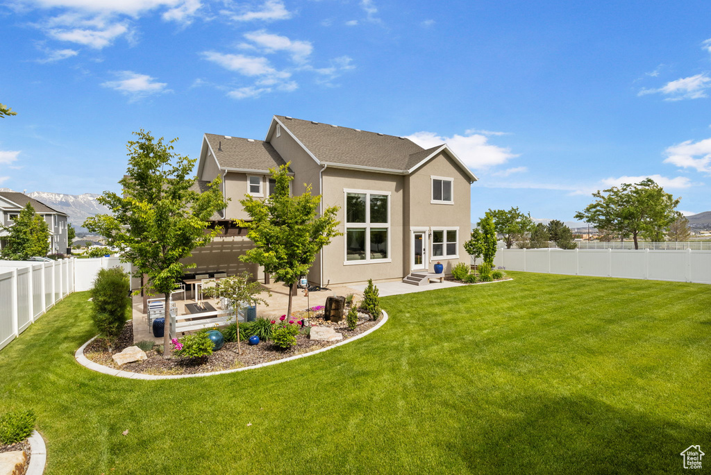 Rear view of property with a patio area, stucco siding, and a mountain view