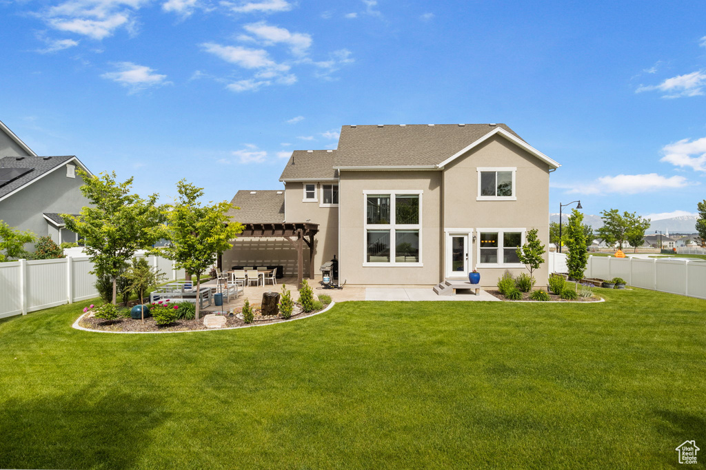 Rear view of property featuring a pergola, a patio area, stucco siding, and roof with shingles