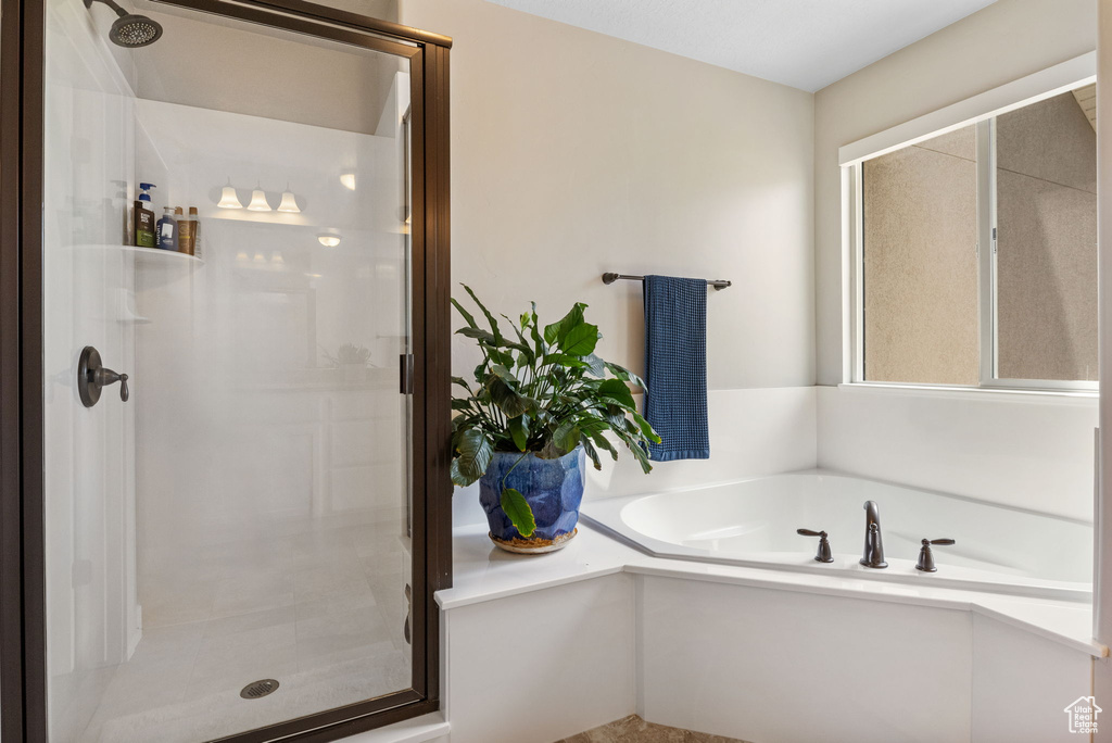 Bathroom featuring a stall shower and a garden tub