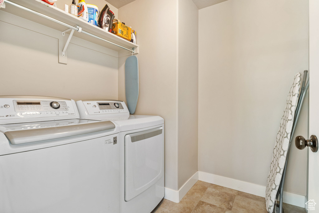 Washroom featuring washing machine and clothes dryer and baseboards