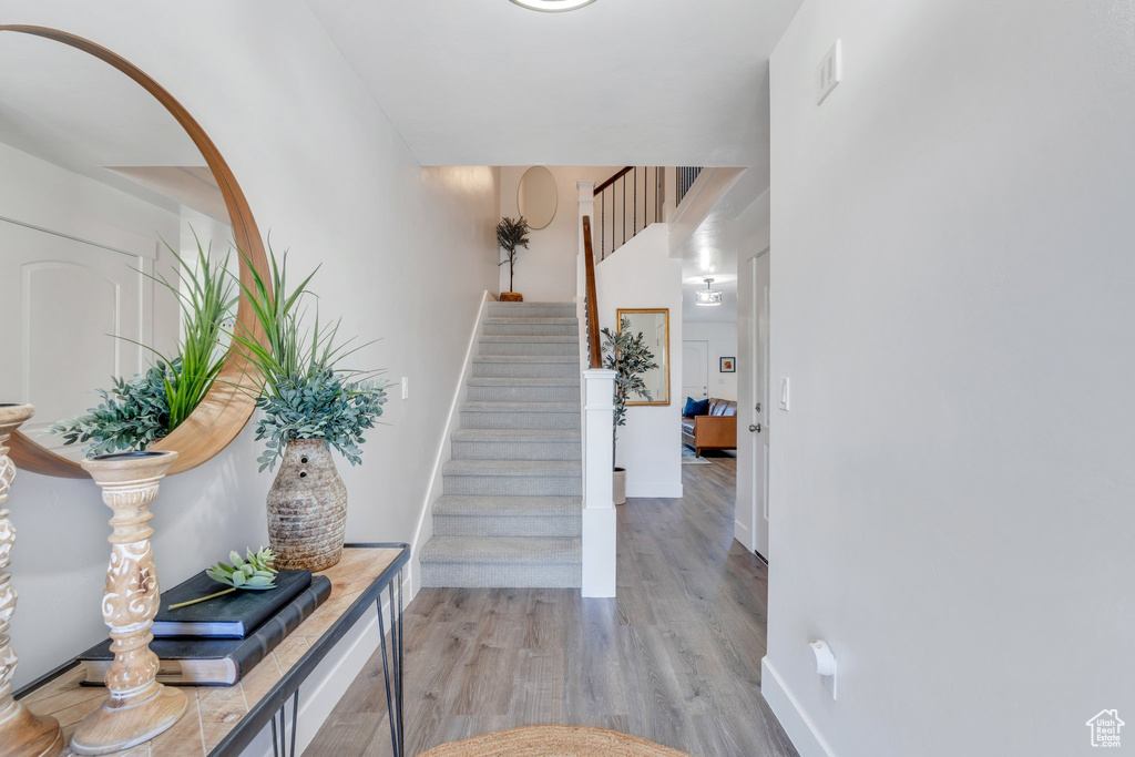 Foyer entrance featuring light wood-type flooring, stairs, and baseboards