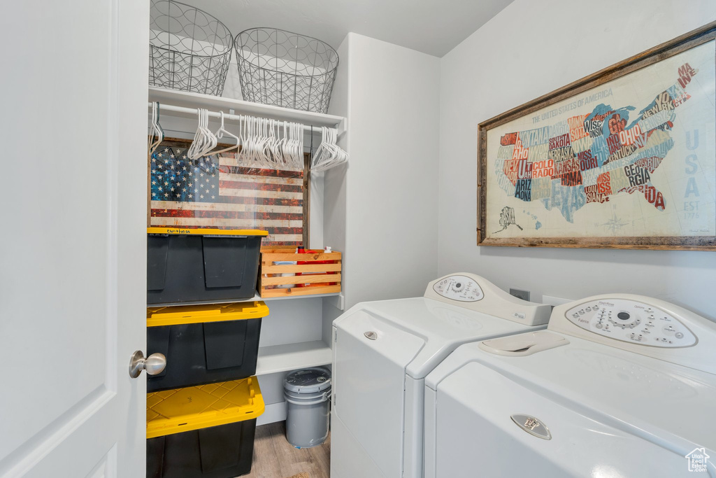 Laundry room featuring washing machine and clothes dryer and wood finished floors