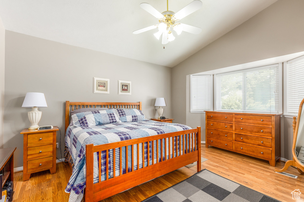 Bedroom featuring lofted ceiling, wood finished floors, baseboards, and ceiling fan