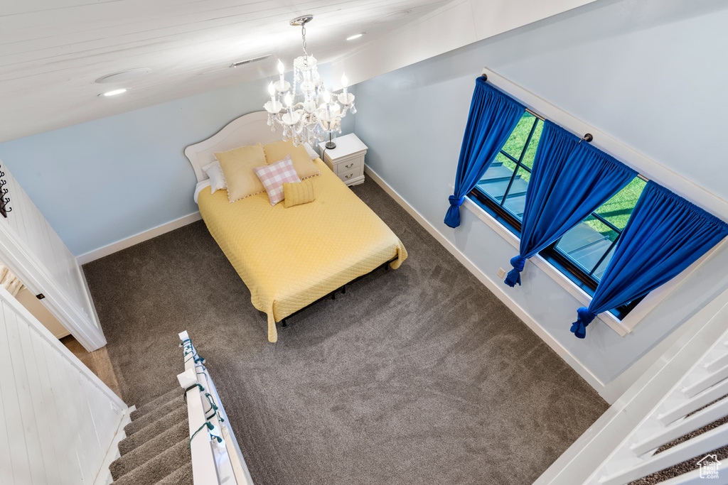 Bedroom with carpet floors, baseboards, and a chandelier