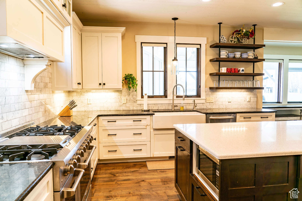 Kitchen featuring stainless steel appliances, a sink, recessed lighting, dark stone counters, and decorative backsplash