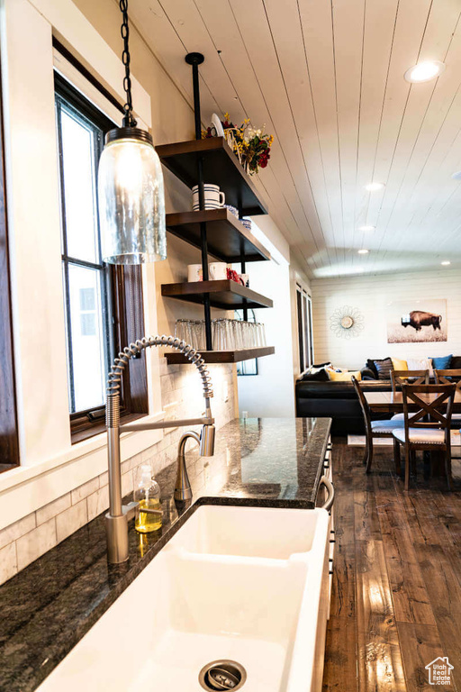 Kitchen with a sink, dark wood-style flooring, wood ceiling, open shelves, and tasteful backsplash