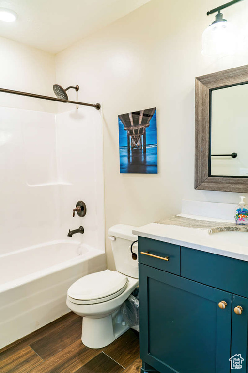 Full bathroom with wood finished floors, vanity, toilet, and shower / bath combination
