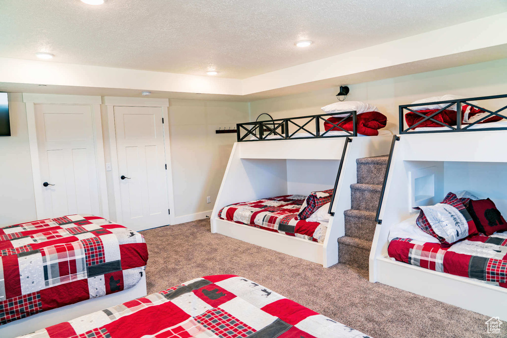 Carpeted bedroom featuring a textured ceiling and recessed lighting