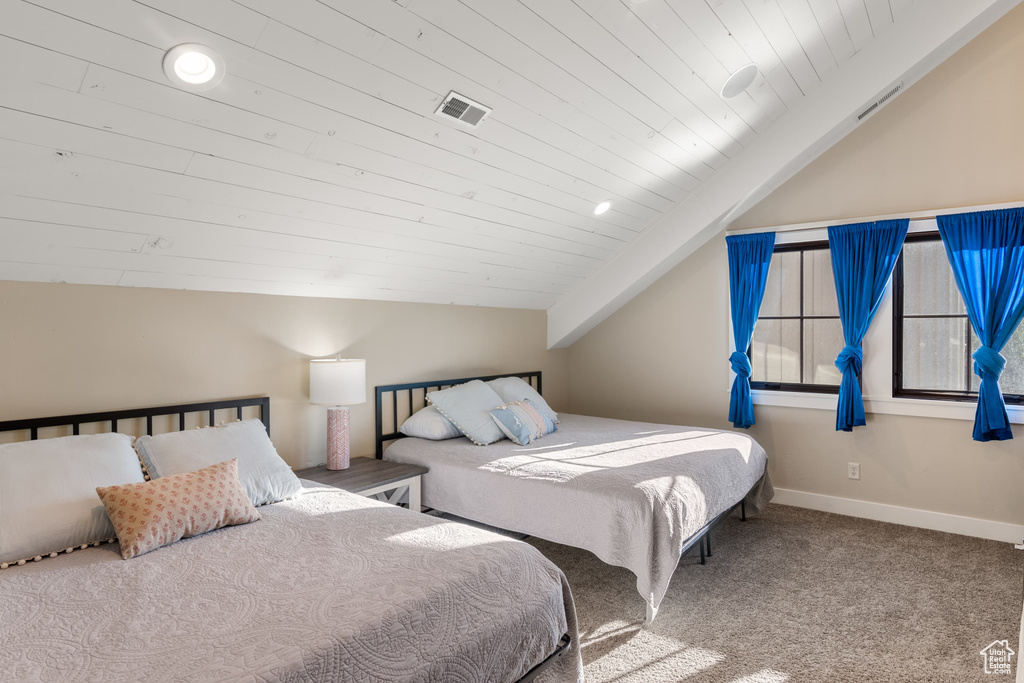 Bedroom with vaulted ceiling, wood ceiling, carpet flooring, and baseboards