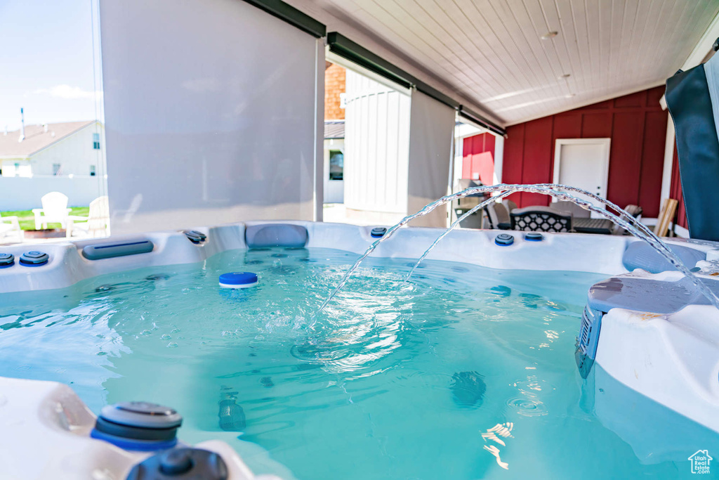 View of pool with a hot tub