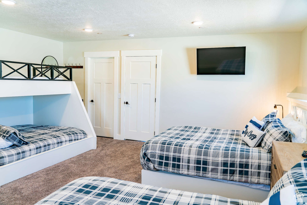 Bedroom with carpet flooring, recessed lighting, and a textured ceiling