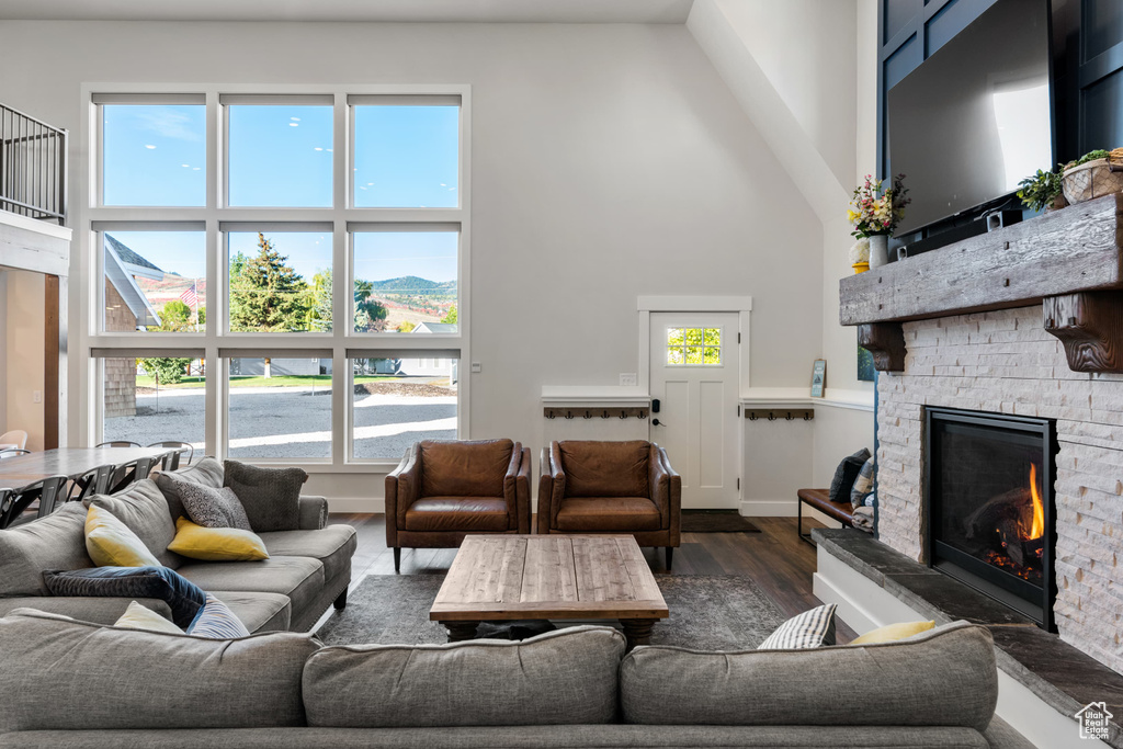 Living room featuring a high ceiling, a fireplace, and dark wood finished floors
