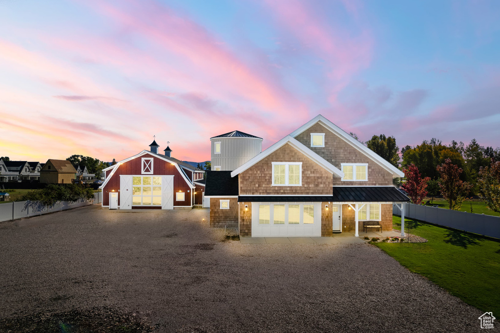 View of front of property featuring driveway, a standing seam roof, and metal roof