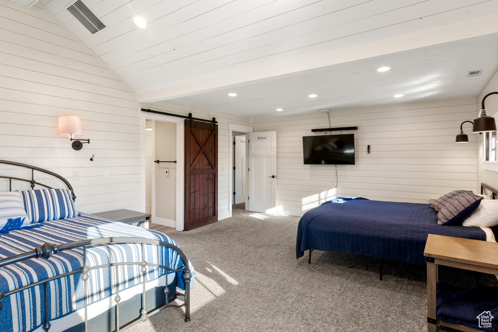 Bedroom with a barn door, wooden walls, carpet flooring, recessed lighting, and lofted ceiling