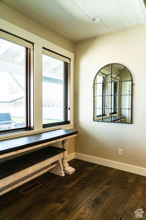 Unfurnished room with baseboards and dark wood-style flooring