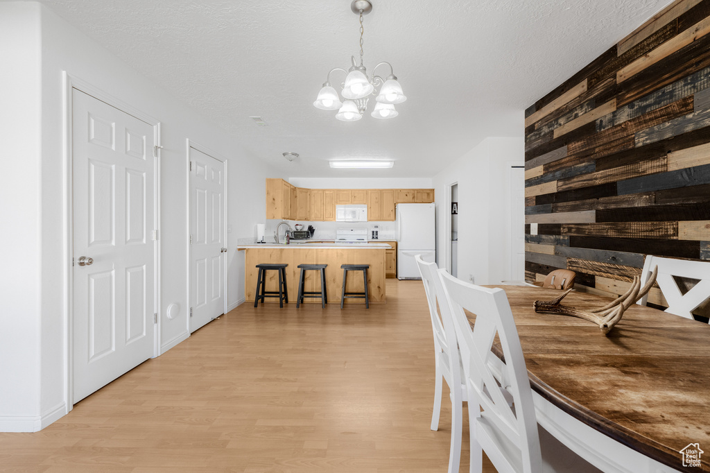 Dining room featuring light wood-style floors and a chandelier