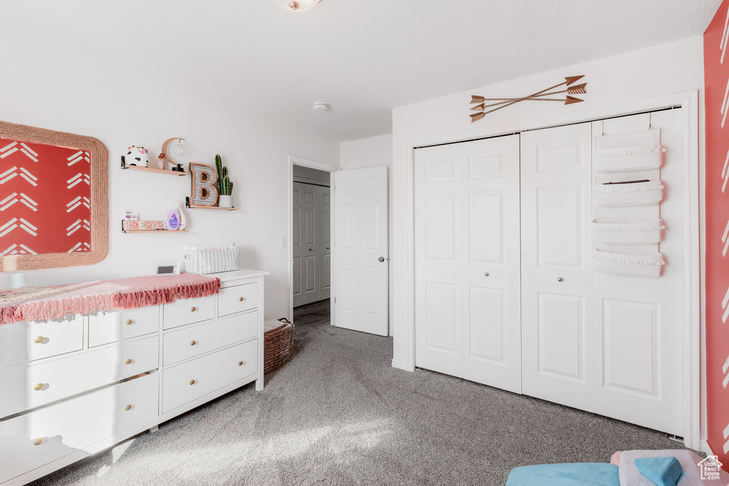 Bedroom featuring light carpet and a closet