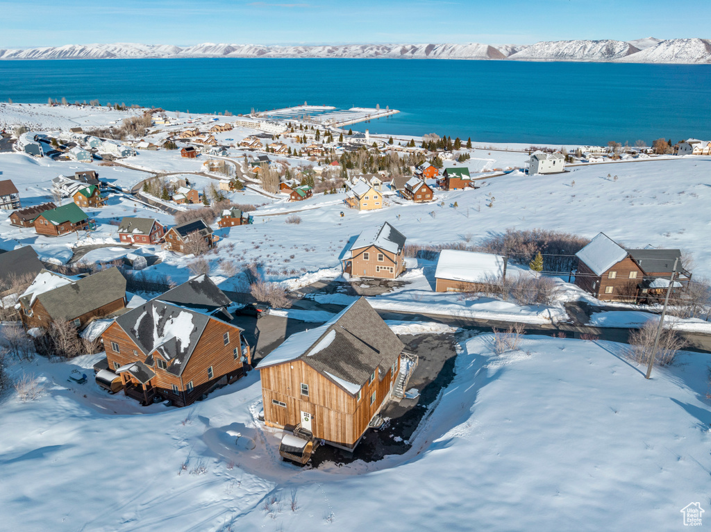 Snowy aerial view featuring a water view