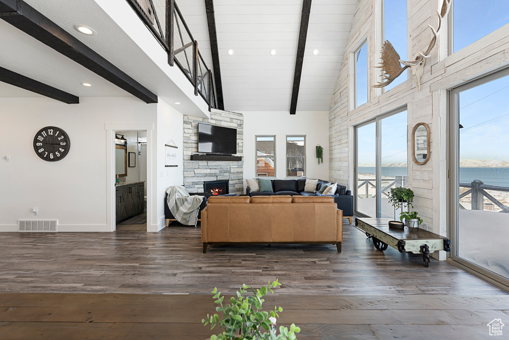 Living area featuring beam ceiling, baseboards, dark wood-style flooring, a fireplace, and recessed lighting