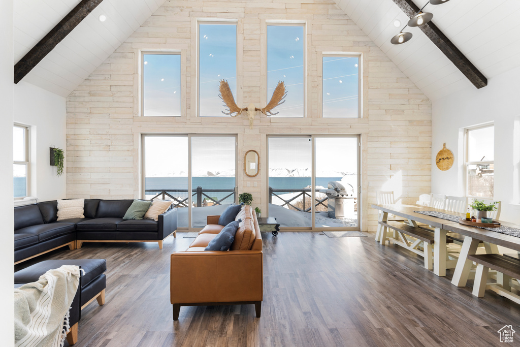 Living area with high vaulted ceiling, wood finished floors, and wooden ceiling with exposed beams