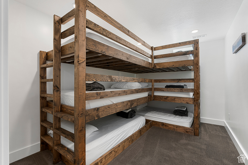 Bedroom featuring baseboards, dark colored carpet, and recessed lighting