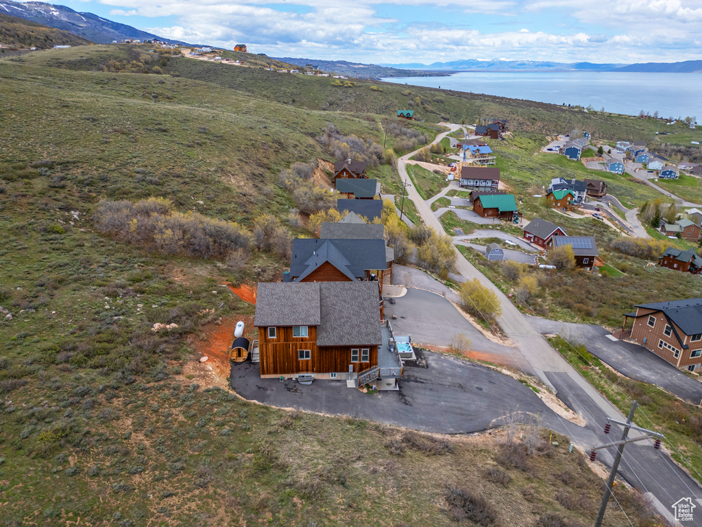 Aerial view of property and surrounding area with a water and mountain view