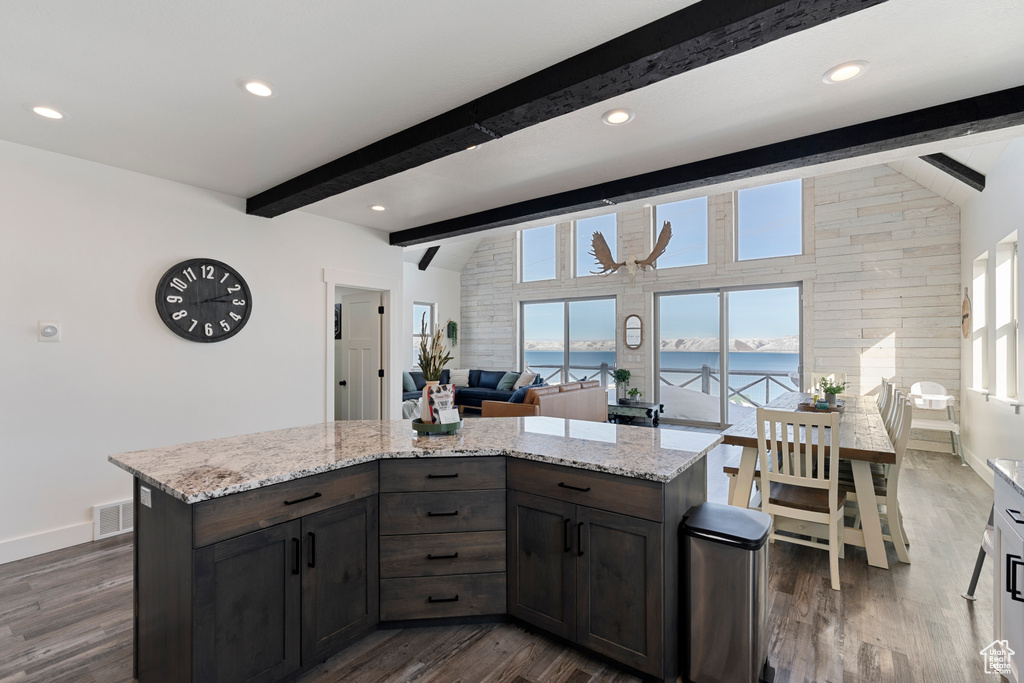 Kitchen featuring a water view, dark wood-style flooring, baseboards, light stone counters, and recessed lighting