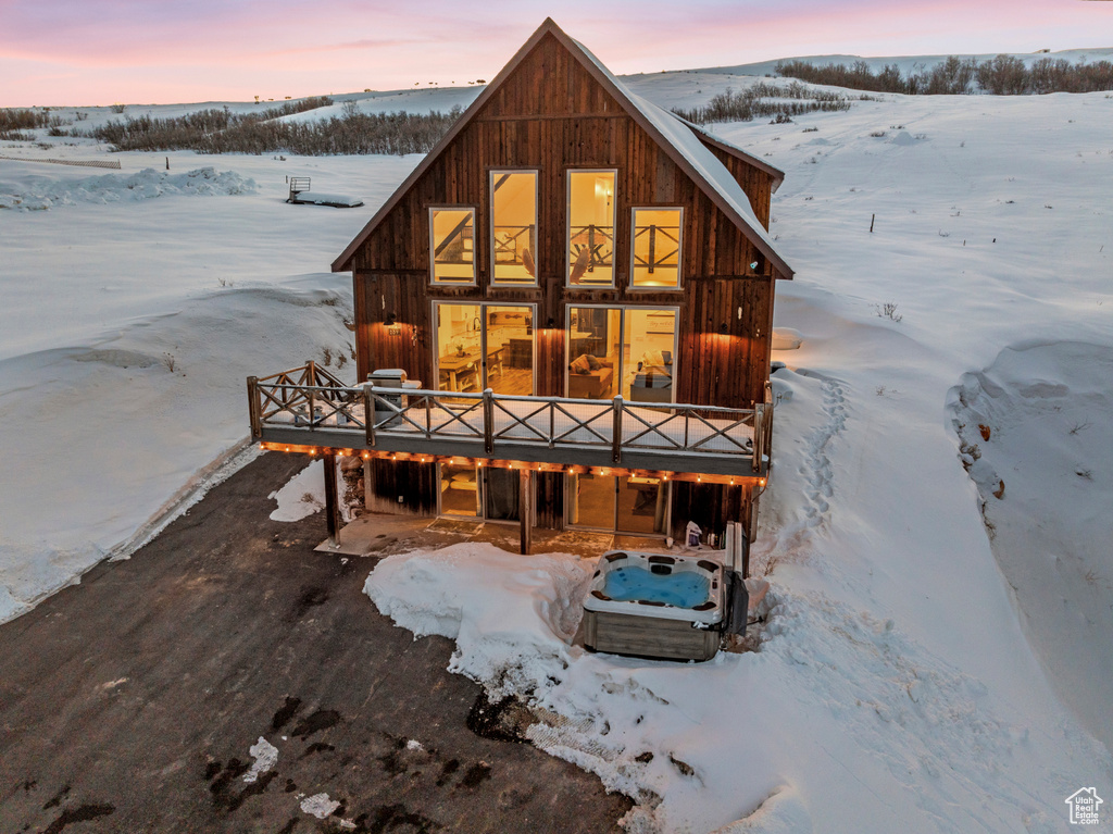 Snow covered rear of property featuring a wooden deck