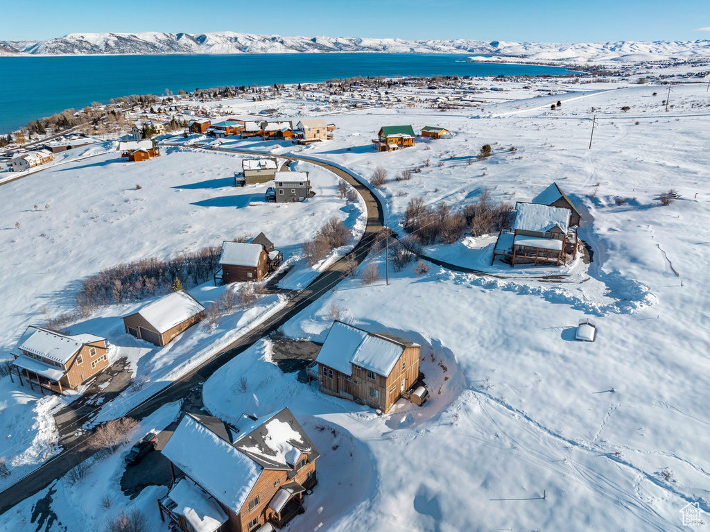 Snowy aerial view with a water and mountain view