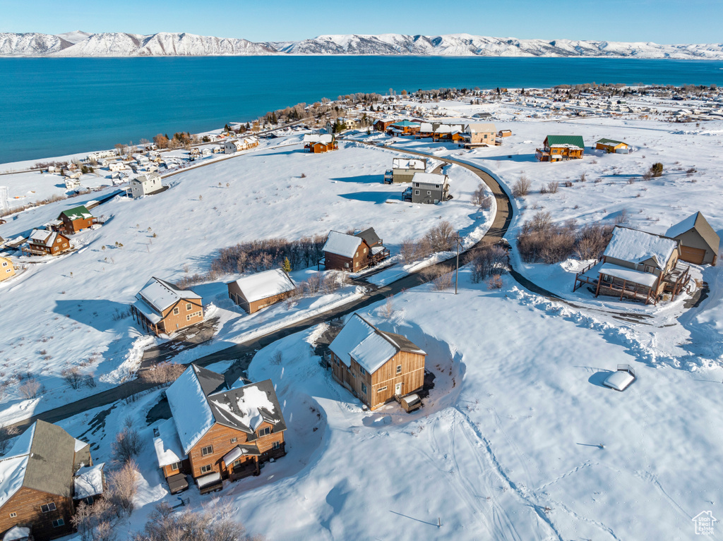 Snowy aerial view featuring a water and mountain view