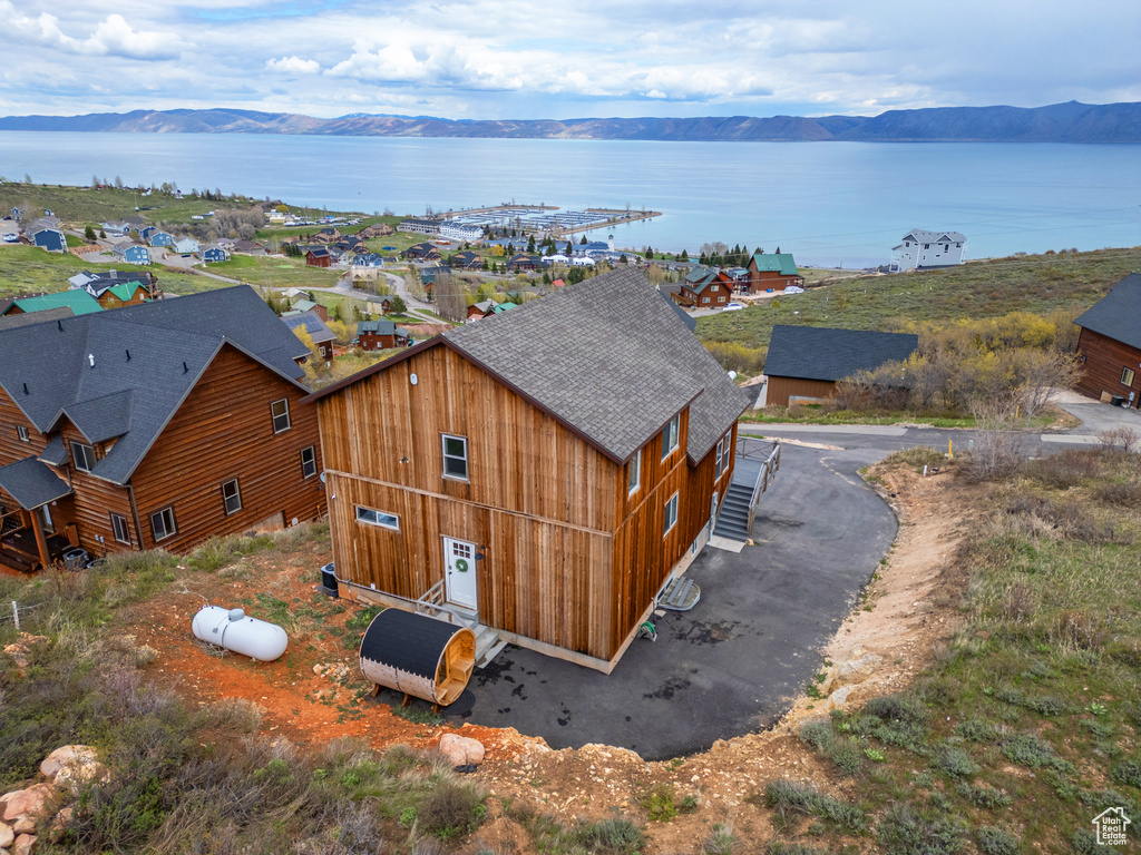 Aerial view of property and surrounding area with a water and mountain view