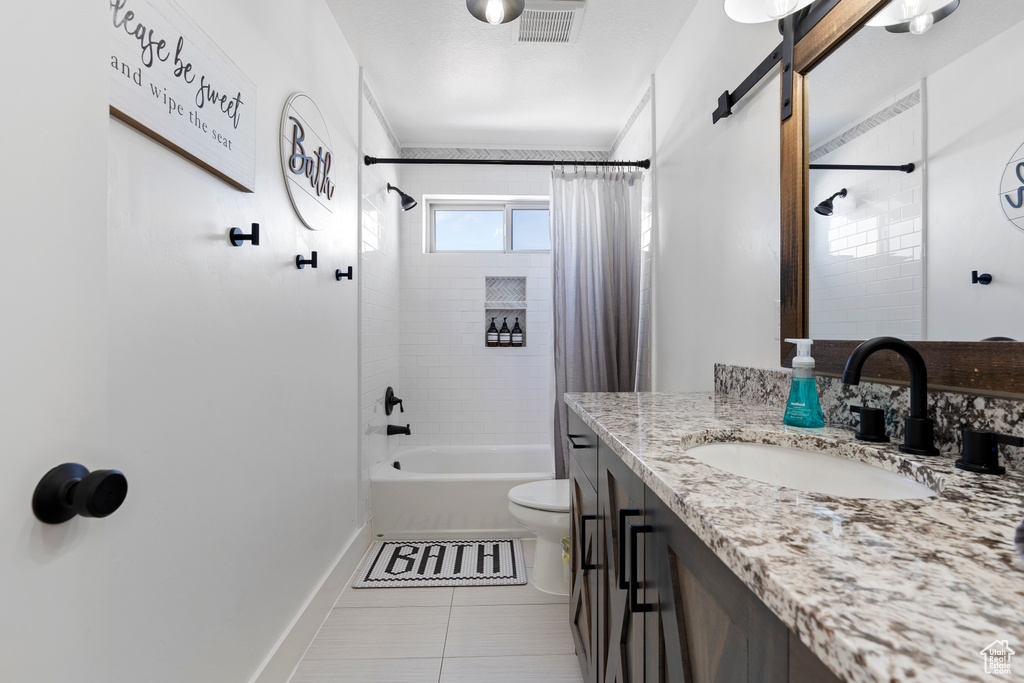 Bathroom featuring vanity, toilet, shower / bathtub combination with curtain, baseboards, and tile patterned floors