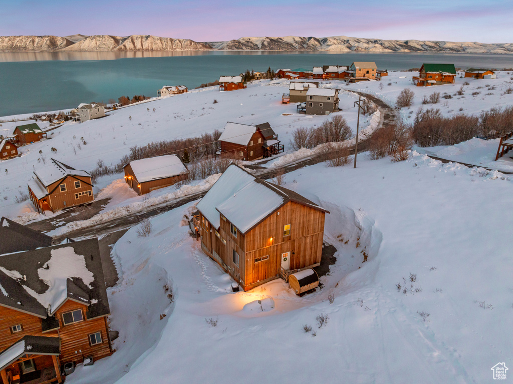 Snowy aerial view featuring a water and mountain view