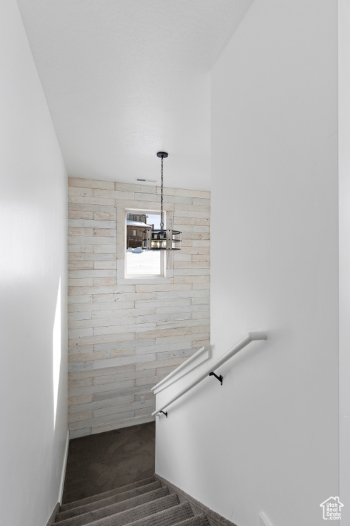 Stairs with carpet floors, a chandelier, and baseboards