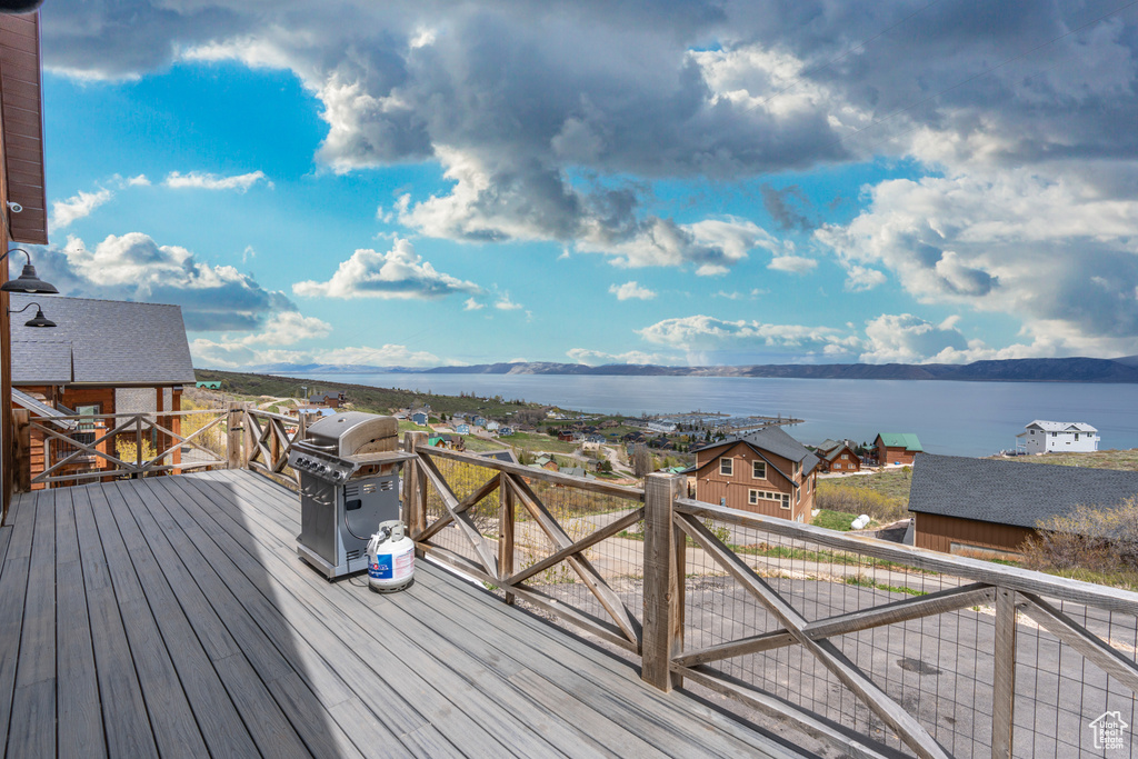 Wooden deck featuring a water view and grilling area