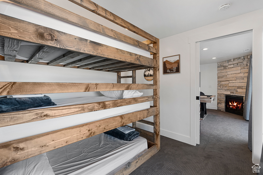 Bedroom with carpet floors, a fireplace, and baseboards