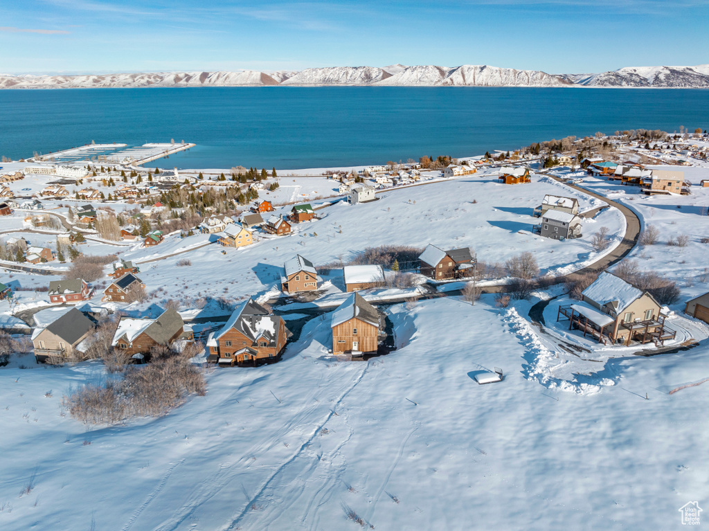 Snowy aerial view with a water and mountain view