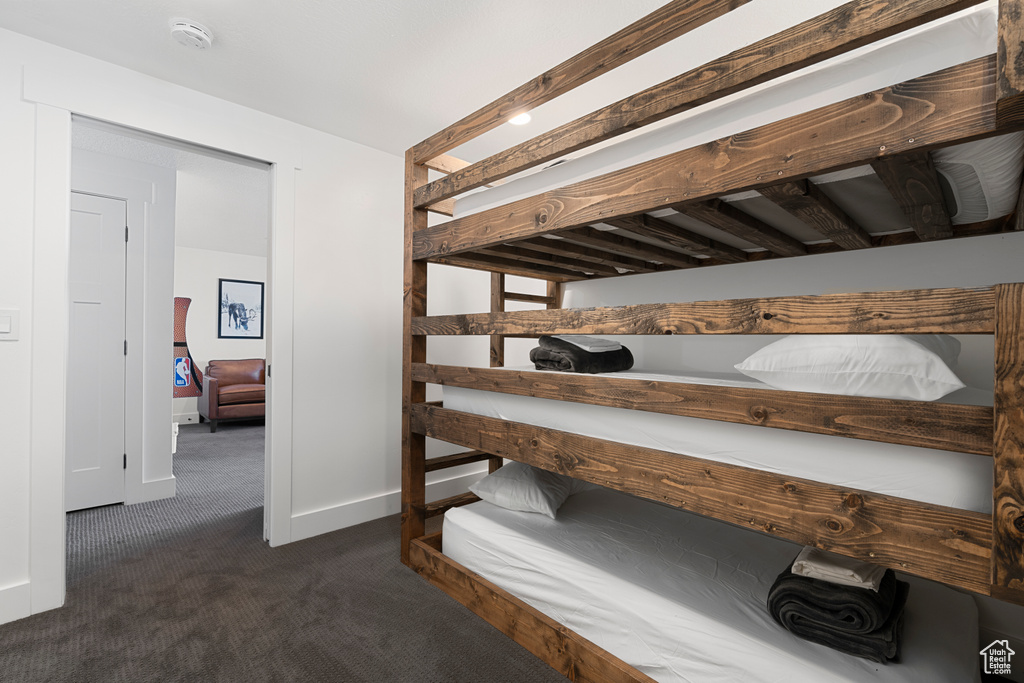 Bedroom with dark colored carpet and baseboards