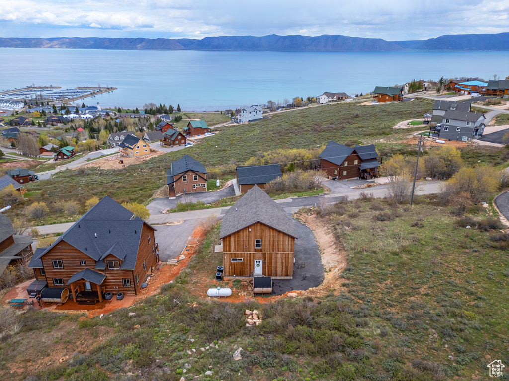 Aerial view of property and surrounding area featuring a water and mountain view