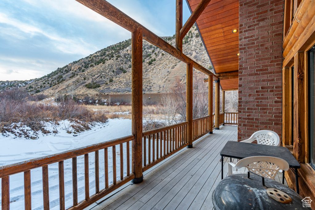 Snow covered deck with a mountain view