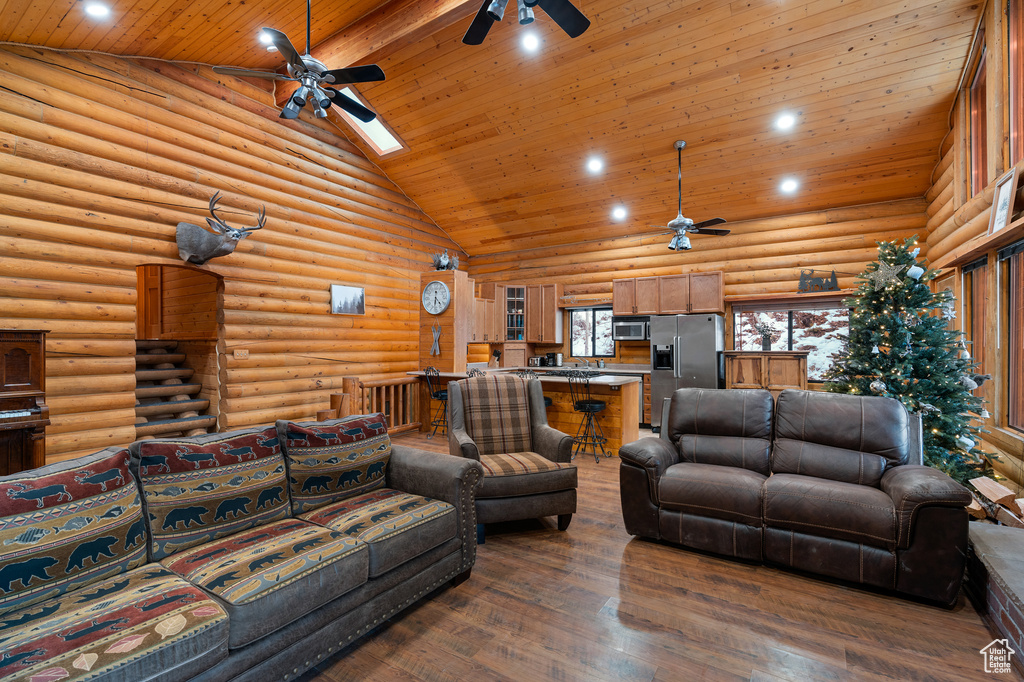 Living area with a ceiling fan, high vaulted ceiling, wooden ceiling, recessed lighting, and dark wood-style floors