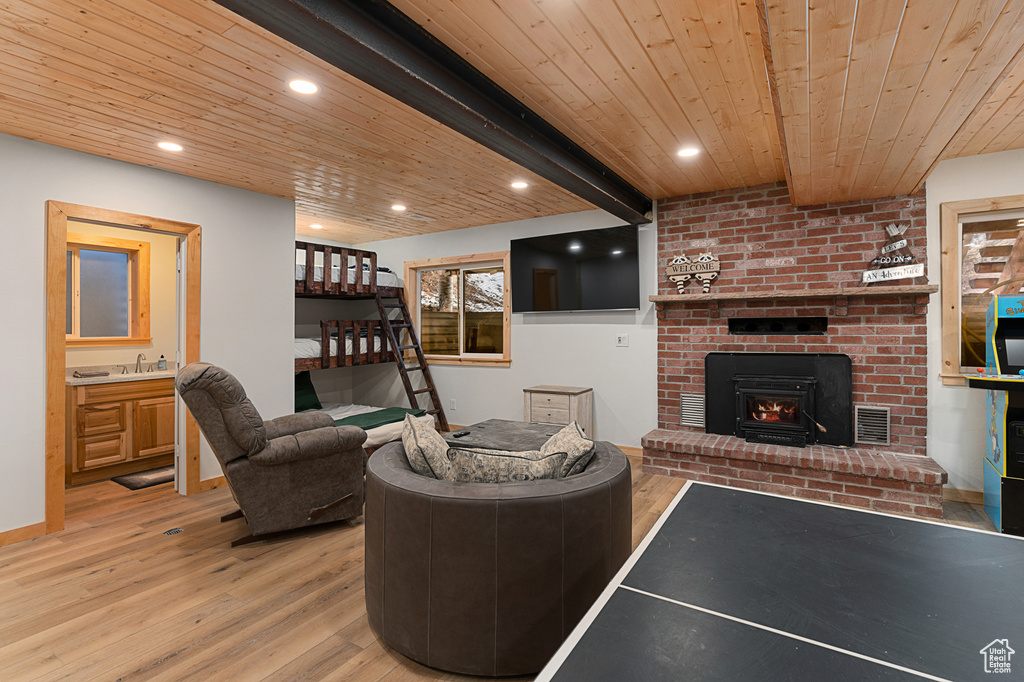 Living room with wood finished floors, wooden ceiling, a brick fireplace, and recessed lighting
