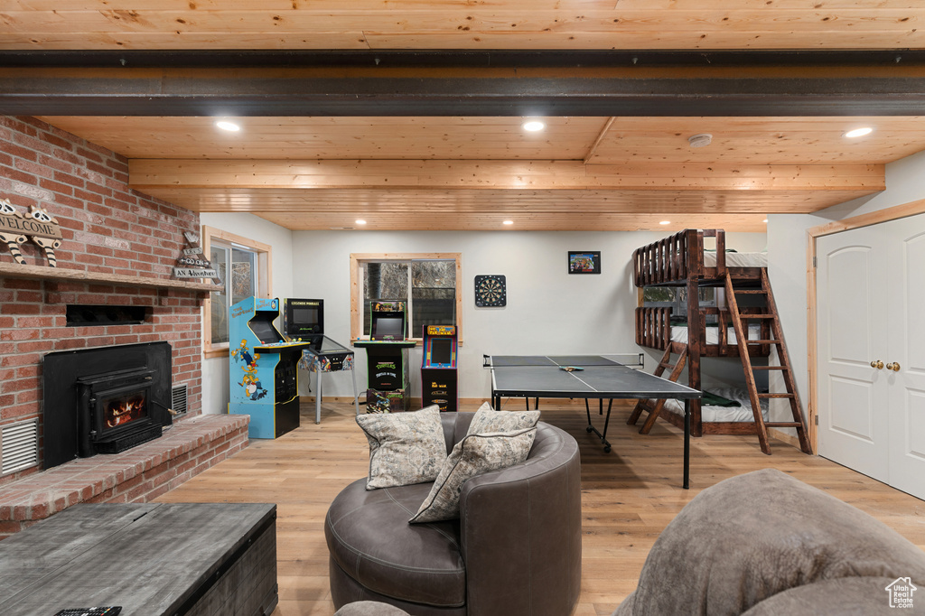 Living room with wood finished floors, recessed lighting, wooden ceiling, and a fireplace