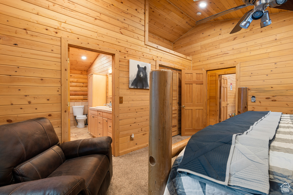 Bedroom featuring wood ceiling, wood walls, ensuite bath, high vaulted ceiling, and a sink